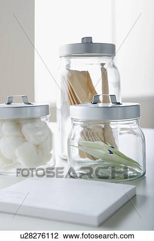 Stock Image - Cotton swabs and tongue depressors in jars. Fotosearch