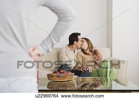 Picture - Couple kissing on sofa. Fotosearch