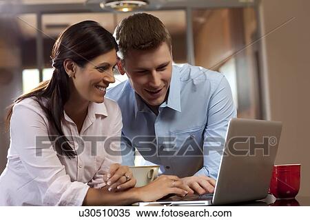Stock Photography - Couple looking at laptop. Fotosearch