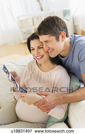 Stock Photo - Couple looking at ultrasound photo. Fotosearch