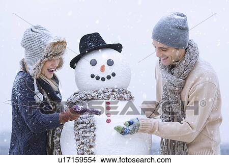Couple making snowman View Large Photo Image Picture - Couple making snowman. Fotosearch
