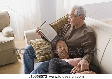 Stock Image - Couple relaxing on sofa. Fotosearch