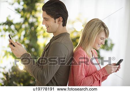 Couple text messaging View Large Photo Image Stock Image - Couple text messaging. Fotosearch