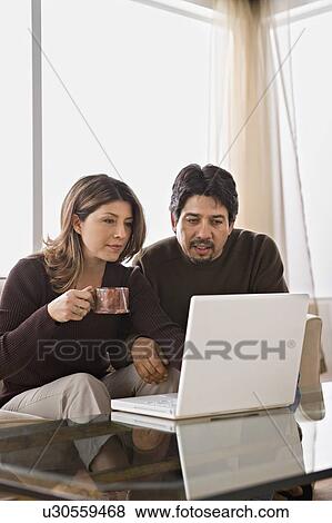 Stock Photo - Couple using laptop together. Fotosearch