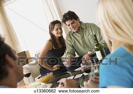 Couples on sofa at home party playing cards View Large Photo Image Stock Image - Couples on sofa at home party playing cards. Fotosearch
