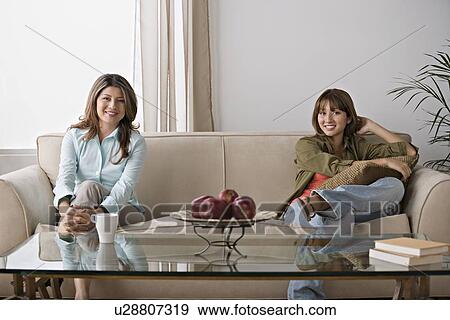 Stock Photo - Daughter sitting with mother on sofa. Fotosearch