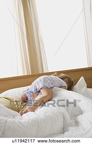 Stock Photo - Daughter waking up father. Fotosearch