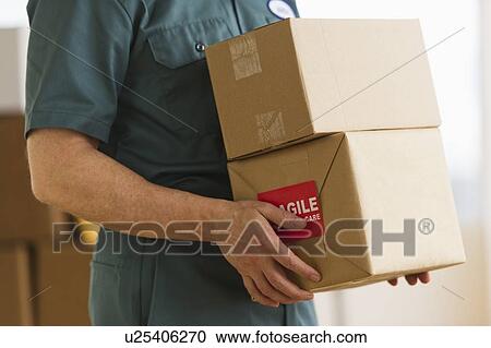 Stock Image - Deliver man carrying boxes. Fotosearch