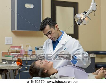 Dentist and patient in dental surgery View Large Photo Image Stock Photo - Dentist and patient in dental surgery. Fotosearch
