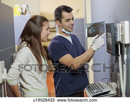Dentist and patient looking at x-ray View Large Photo Image Stock Image - Dentist and patient looking at x-ray . Fotosearch