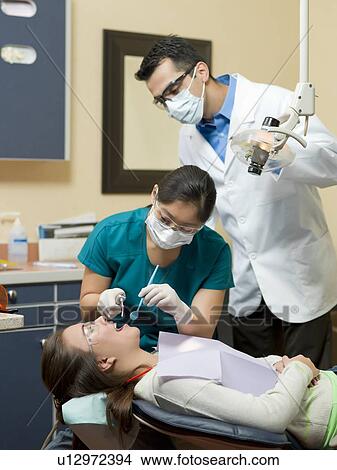 Dentists and patient in dental surgery View Large Photo Image Picture - Dentists and patient in dental surgery. Fotosearch