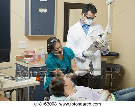 Dentists and patient in dental surgery View Large Photo Image Stock Photo - Dentists and patient in dental surgery. Fotosearch