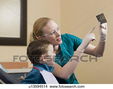 Dentists showing x-ray image to patient View Large Photo Image Picture - Dentists showing x-ray image to patient. Fotosearch