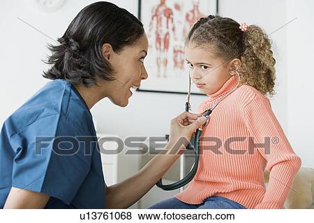 Stock Photo - Doctor examining girl (10-11). Fotosearch