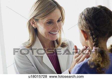 Stock Photo - Doctor examining girl (10-11). Fotosearch