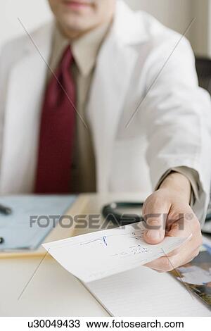Stock Image - Doctor holding prescription. Fotosearch