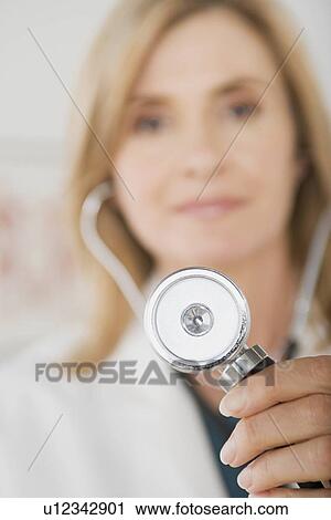 Stock Image - Doctor holding stethoscope. Fotosearch