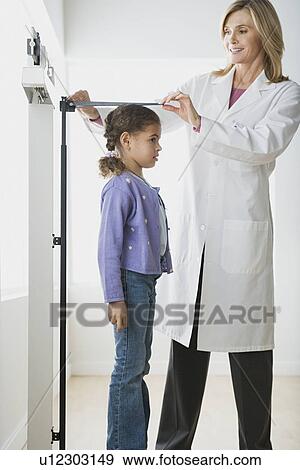 Doctor measuring girl (10-11) View Large Photo Image Stock Photo - Doctor measuring girl (10-11). Fotosearch