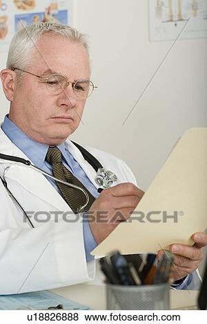 Doctor reading medical document View Large Photo Image Stock Photo - Doctor reading medical document. Fotosearch