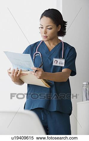 Doctor reading medical documents View Large Photo Image Stock Photography - Doctor reading medical documents. Fotosearch