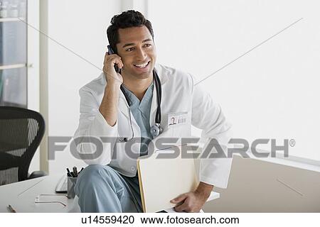 Doctor talking on mobile phone View Large Photo Image Stock Image - Doctor talking on mobile phone. Fotosearch