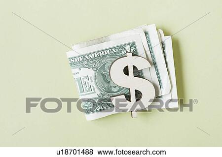 Stock Photo - Dollar banknotes in dollar symbol shaped money clip, studio shot. Fotosearch