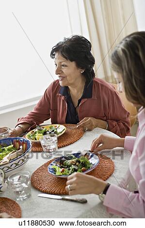 Stock Image - Family having meal together. Fotosearch