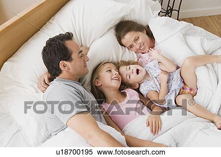 Family with two children chilling in bed View Large Photo Image Stock Photography - Family with two children chilling in bed. Fotosearch