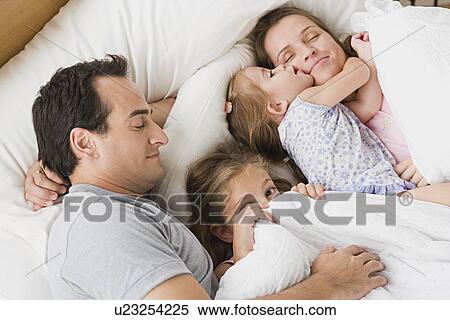 Family with two children chilling in bed View Large Photo Image Stock Photography - Family with two children chilling in bed. Fotosearch