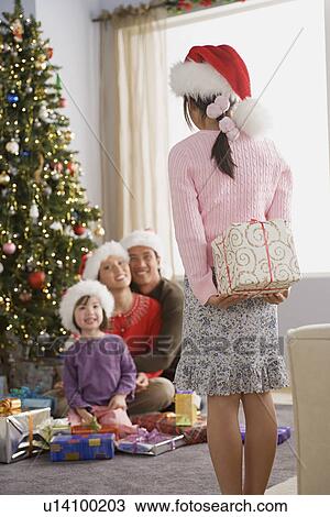 Stock Image - Family with two daughters (10-11) at Christmas morning. Fotosearch