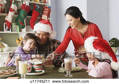 Family with two daughters (10-11) enjoying christmas meal View Large Photo Image Stock Image - Family with two daughters (10-11) enjoying christmas meal. Fotosearch