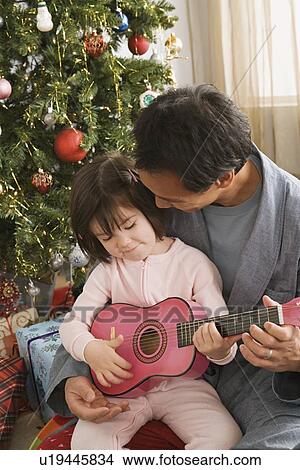 Father and daughter at Christmas tree View Large Photo Image Picture - Father and daughter at Christmas tree. Fotosearch