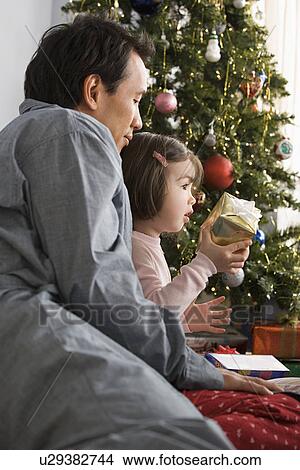 Picture - Father and daughter at Christmas tree. Fotosearch