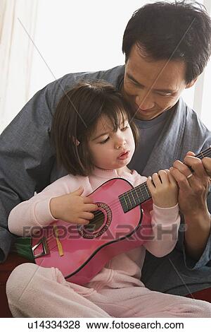 Father and daughter playing guitar View Large Photo Image Stock Photo - Father and daughter playing guitar. Fotosearch