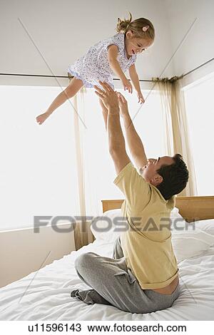 Father playing with daughter in bedroom View Large Photo Image Stock Image - Father playing with daughter in bedroom. Fotosearch