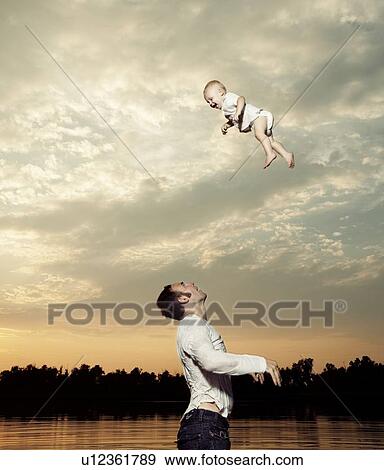 Stock Photo - Father tossing baby son up in air. Fotosearch