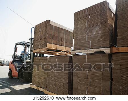 Stock Image - Forklift truck moving pallets. Fotosearch