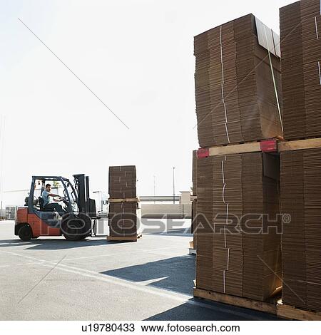 Stock Image - Forklift truck moving pallets. Fotosearch