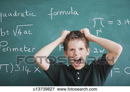 Stock Photo - Frustrated schoolboy in front of blackboard. Fotosearch