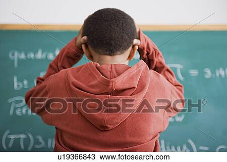Frustrated schoolboy standing in front of blackboard View Large Photo Image Stock Image - Frustrated schoolboy standing in front of blackboard. Fotosearch