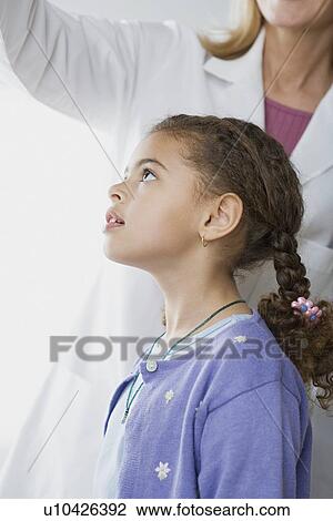 Stock Image - Girl (10-11) and doctor. Fotosearch