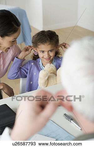 Stock Image - Girl (10-11) with mother in doctor's office. Fotosearch