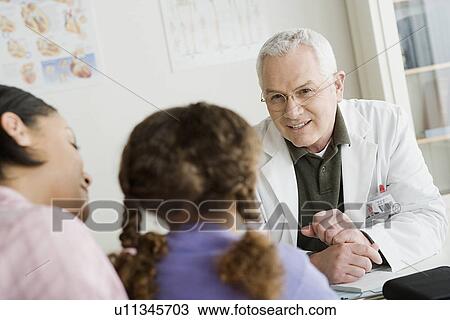 Girl (10-11) with mother talking to doctor View Large Photo Image Stock Image - Girl (10-11) with mother talking to doctor. Fotosearch