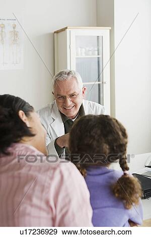 Girl (10-11) with mother talking to doctor View Large Photo Image Stock Photo - Girl (10-11) with mother talking to doctor. Fotosearch