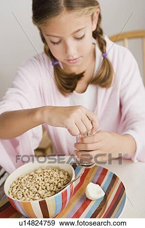 Stock Photo - Girl (12-13) eating breakfast. Fotosearch