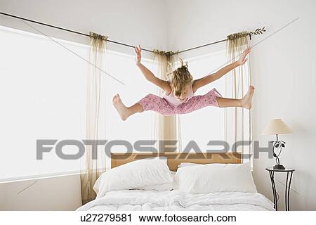 Girl (12-13) jumping on bed View Large Photo Image Stock Image - Girl (12-13) jumping on bed. Fotosearch