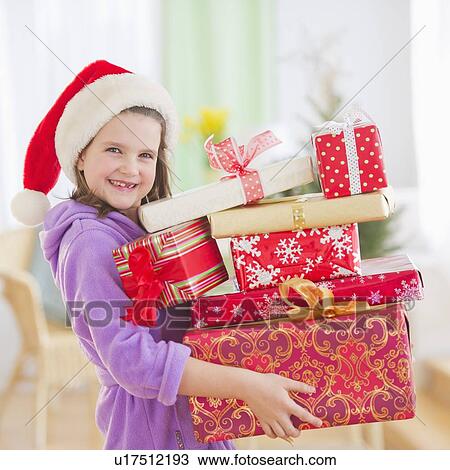 Girl (8-9) carrying christmas gifts View Large Photo Image Stock Image - Girl (8-9) carrying christmas gifts. Fotosearch