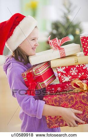 Girl (8-9) carrying christmas gifts View Large Photo Image Stock Photo - Girl (8-9) carrying christmas gifts. Fotosearch