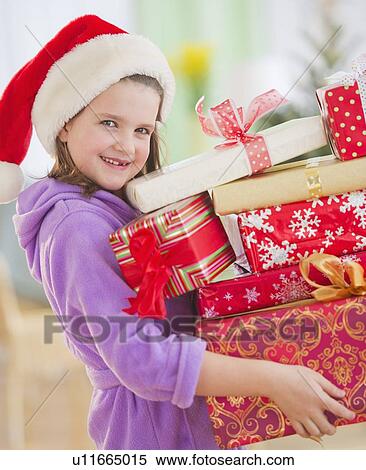Girl (8-9) carrying christmas gifts View Large Photo Image Stock Photography - Girl (8-9) carrying christmas gifts. Fotosearch
