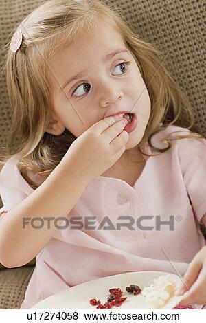 Girl (8-9) eating View Large Photo Image Stock Photo - Girl (8-9) eating. Fotosearch